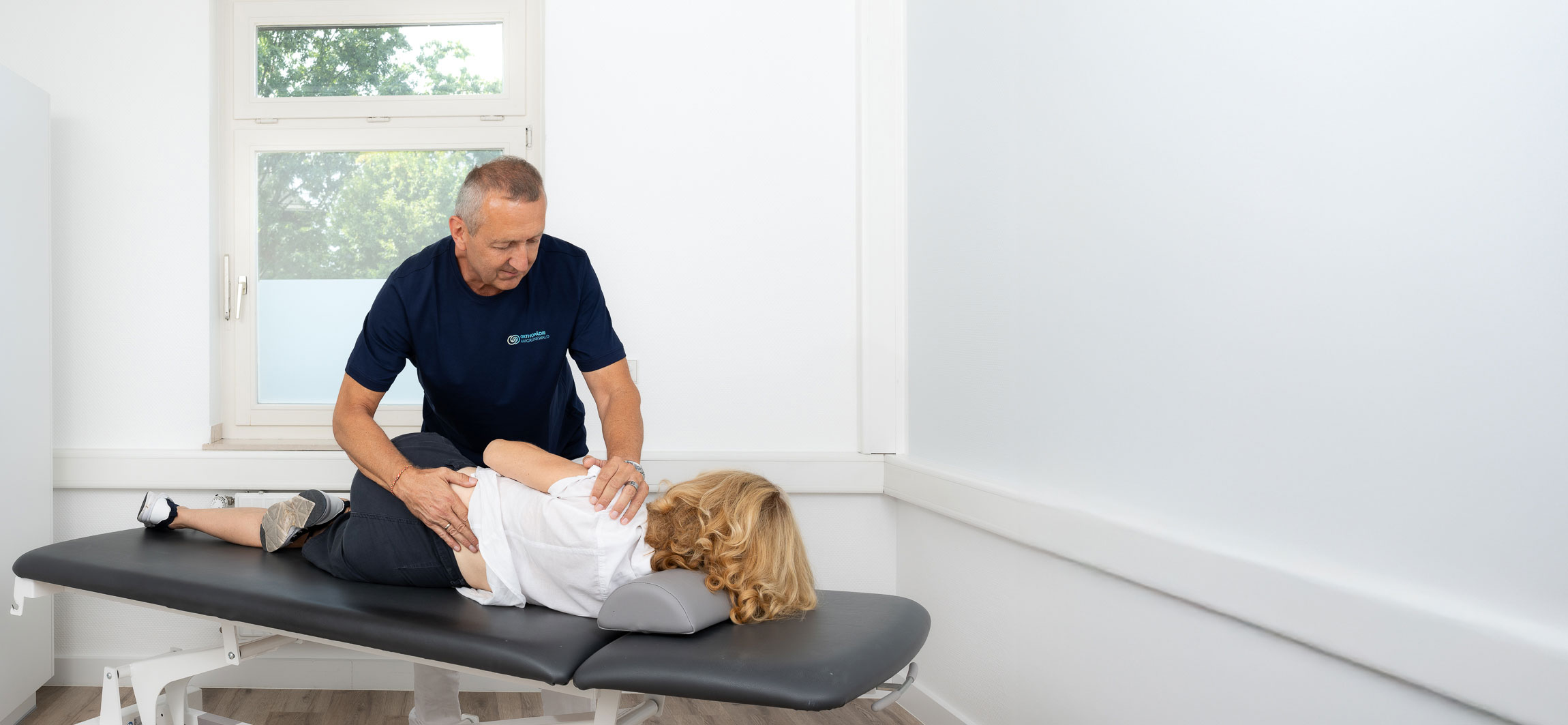 Dr. med. Thomas Fröhlich bei der manualmedizinischen Behandlung einer Patientin in der Praxis Orthopädie am Grünewald