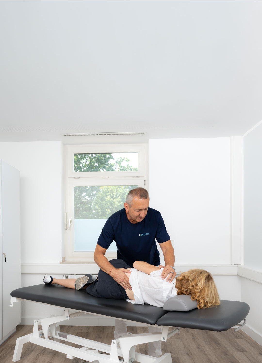 Dr. med. Thomas Fröhlich bei der manualmedizinischen Behandlung einer Patientin in der Praxis Orthopädie am Grünewald