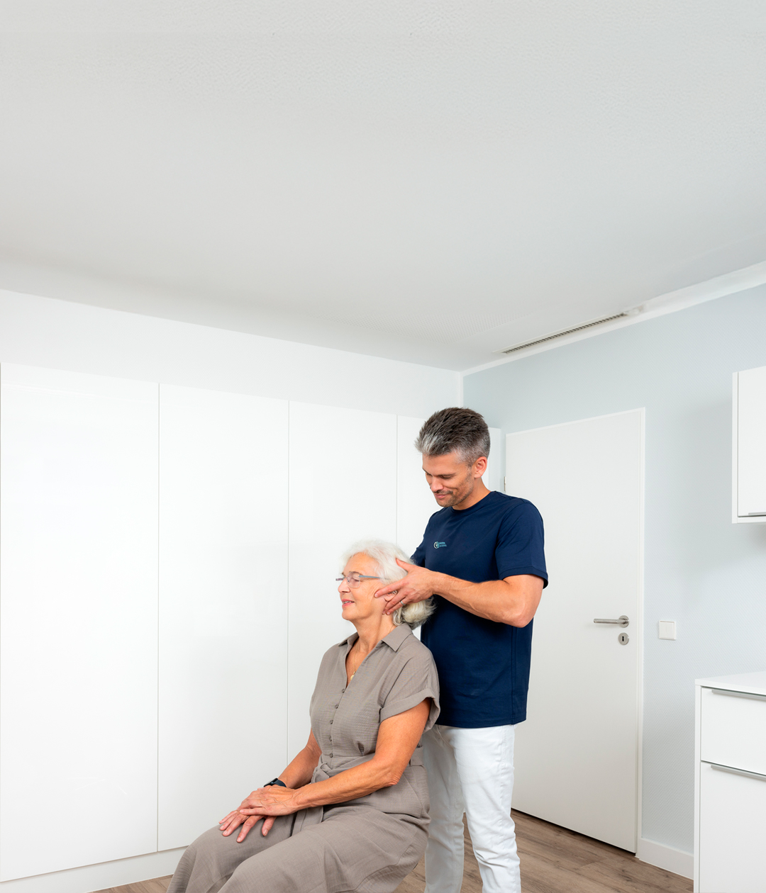 Korbinian Lenz bei der manualmedizinischen Untersuchung einer älteren Patientin in der Praxis Orthopädie am Grünewald